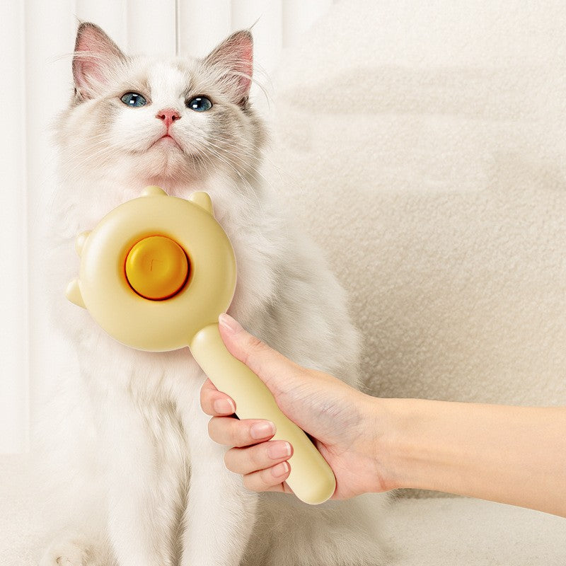 Cat being petted by a hand holding a yellow grooming tool against a neutral background