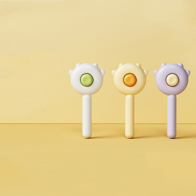 Three colorful handheld toys with round ends on a yellow background